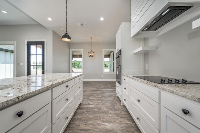 kitchen featuring pendant lighting, white cabinetry, black appliances, and custom range hood