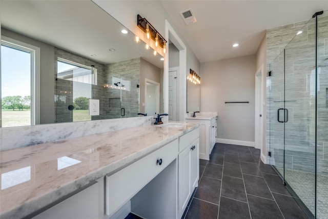 bathroom featuring tile patterned flooring, a shower with door, and vanity