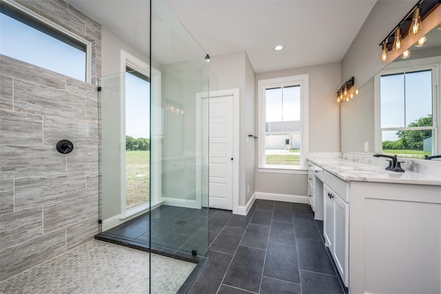 bathroom with tile patterned flooring, tiled shower, and vanity