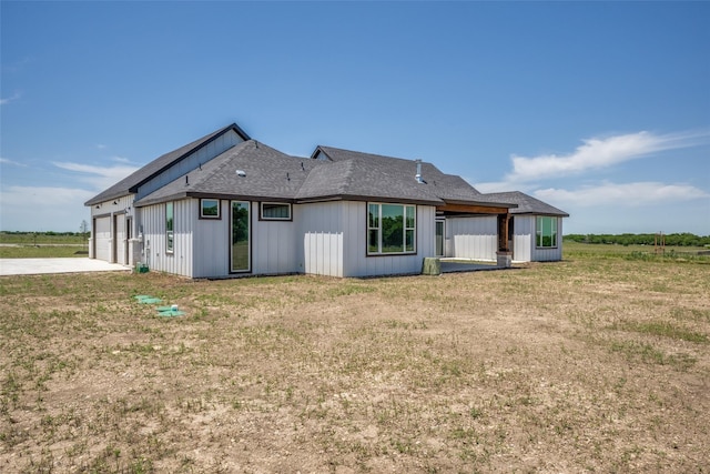 back of house featuring a garage and a yard