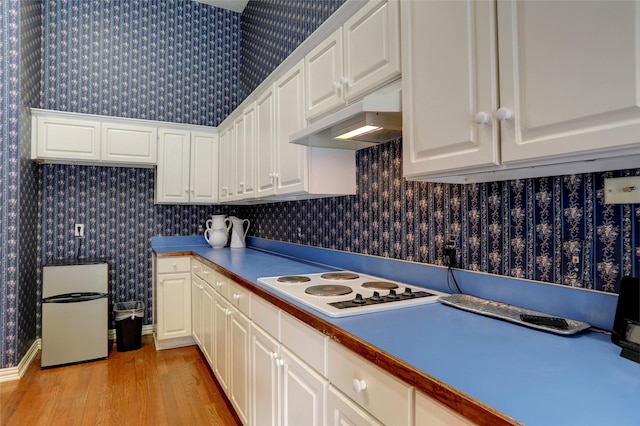 kitchen with white electric stovetop, white cabinetry, wooden counters, and light hardwood / wood-style floors