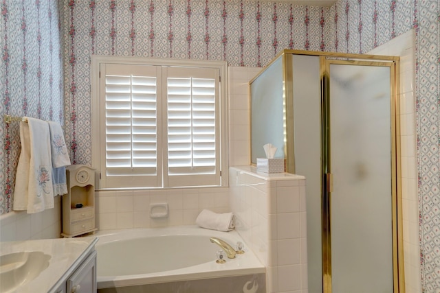 bathroom featuring plus walk in shower, vanity, and plenty of natural light