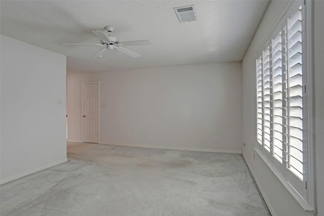 carpeted spare room with ceiling fan and a textured ceiling