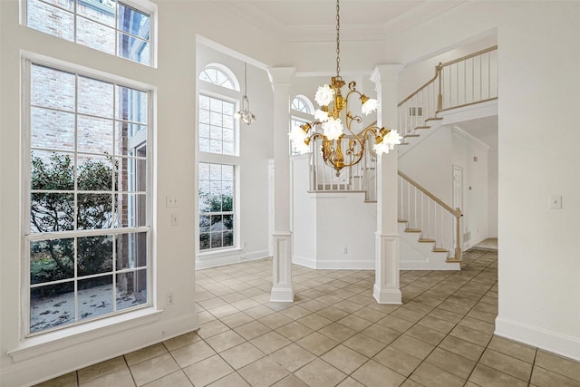 unfurnished dining area featuring tile patterned flooring, ornamental molding, a towering ceiling, a notable chandelier, and decorative columns