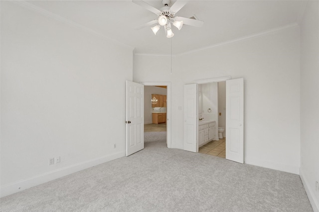 unfurnished bedroom with connected bathroom, ceiling fan, crown molding, and light colored carpet