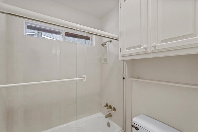 bathroom featuring shower / bath combination with glass door and toilet