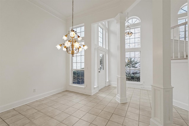 interior space with decorative columns, an inviting chandelier, crown molding, and light tile patterned flooring