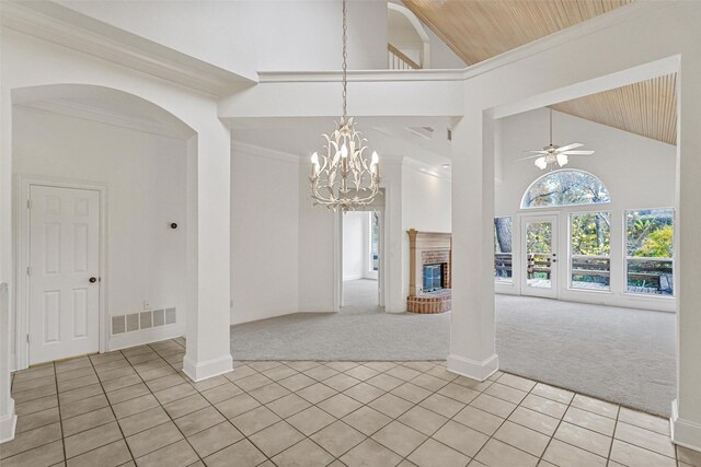 interior space featuring wooden ceiling, a brick fireplace, high vaulted ceiling, light colored carpet, and ceiling fan with notable chandelier