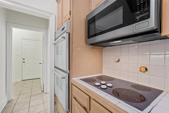 kitchen with tile countertops, light brown cabinets, white appliances, and tasteful backsplash