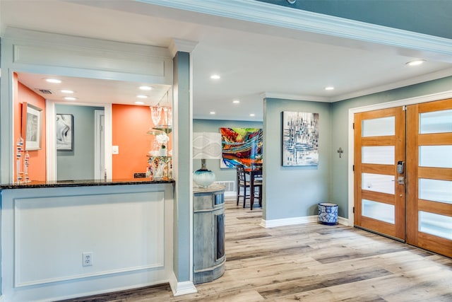 entrance foyer featuring light hardwood / wood-style floors, crown molding, and french doors