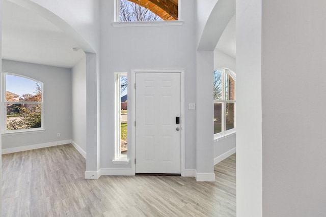 entrance foyer featuring a high ceiling and light wood-type flooring