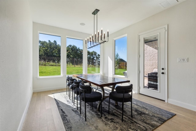 dining area featuring light hardwood / wood-style flooring and an inviting chandelier