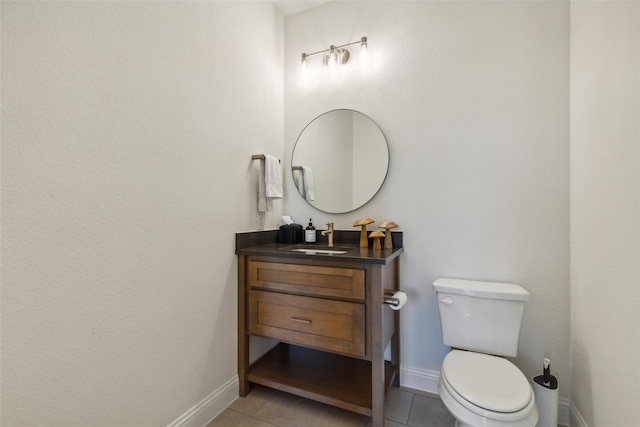 bathroom with toilet, vanity, and tile patterned floors