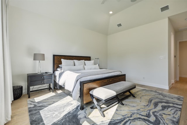 bedroom featuring light hardwood / wood-style flooring, vaulted ceiling, and ceiling fan