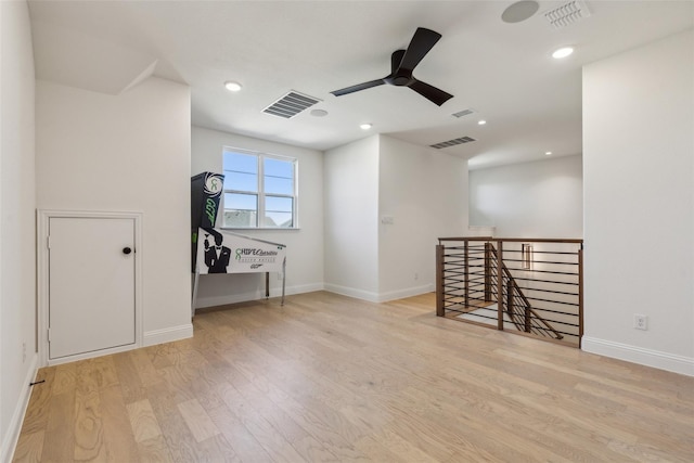 empty room with ceiling fan and light hardwood / wood-style floors