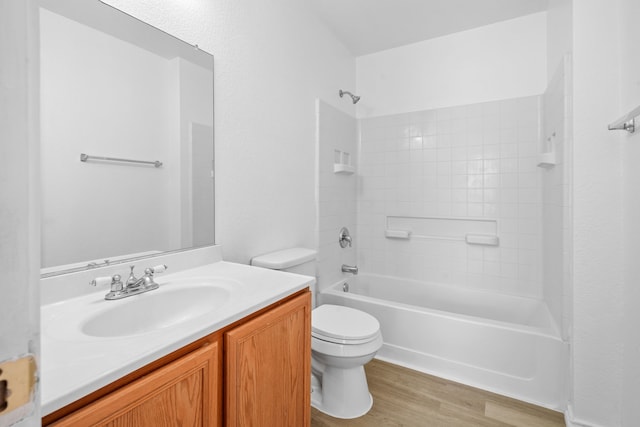 full bathroom featuring hardwood / wood-style flooring, vanity, tiled shower / bath, and toilet