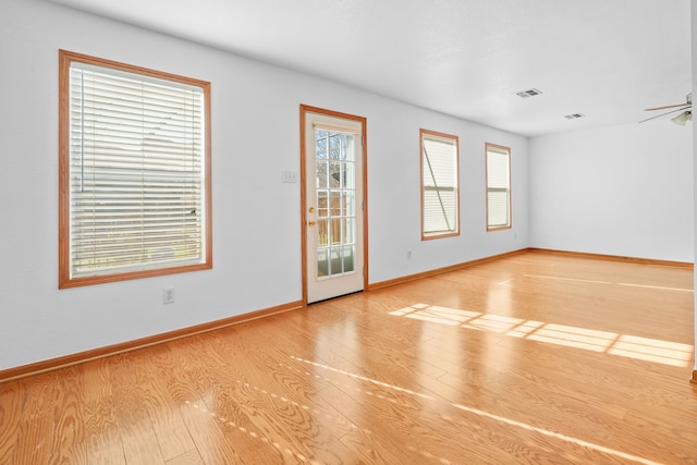 empty room with ceiling fan and light hardwood / wood-style flooring