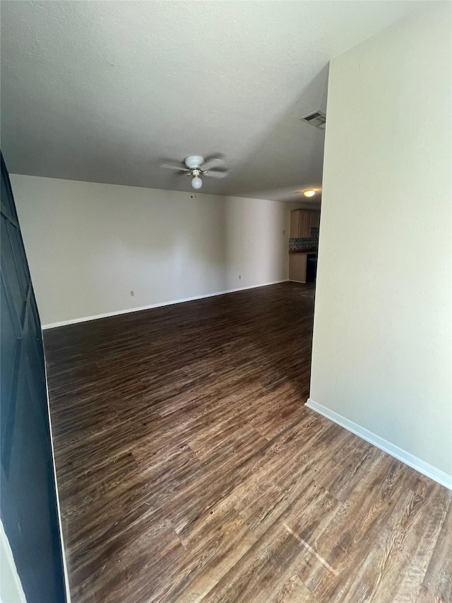 unfurnished living room with dark hardwood / wood-style floors and ceiling fan