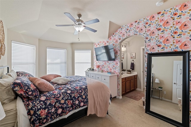 bedroom featuring ensuite bath, ceiling fan, light carpet, and vaulted ceiling