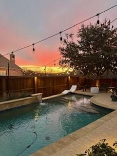 pool at dusk with a patio area