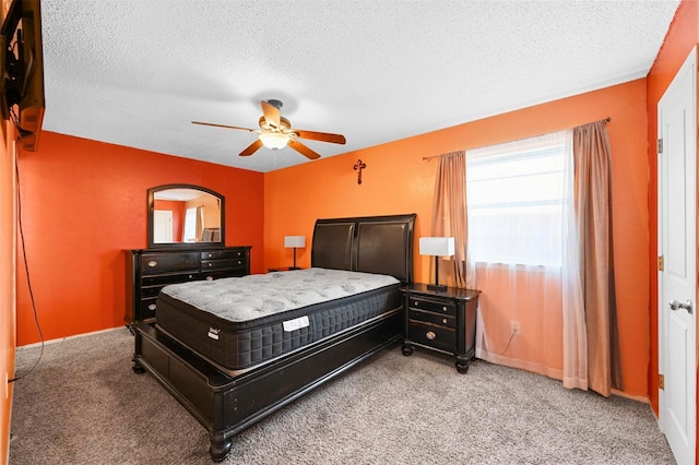 carpeted bedroom featuring ceiling fan and a textured ceiling