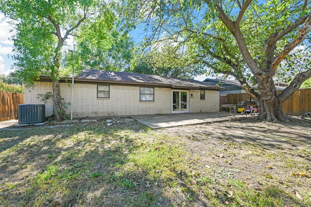 back of property featuring central AC unit, a yard, and a patio