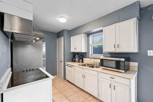 kitchen featuring sink, light tile patterned flooring, a textured ceiling, black electric cooktop, and white cabinets