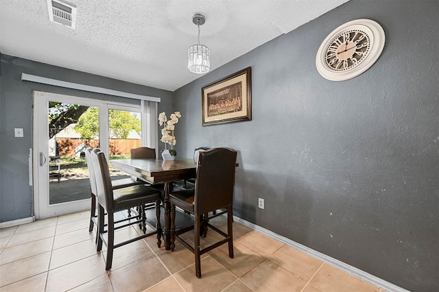 dining space with light tile patterned floors and a textured ceiling