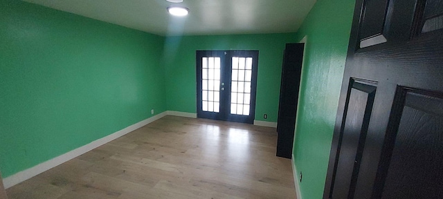 empty room with french doors and light wood-type flooring