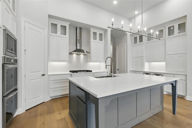 6300 Whitebrush Pl, Fort Worth, TX 76123 - kitchen with wall chimney range hood, a sink, a kitchen island with sink, light countertops, and decorative backsplash