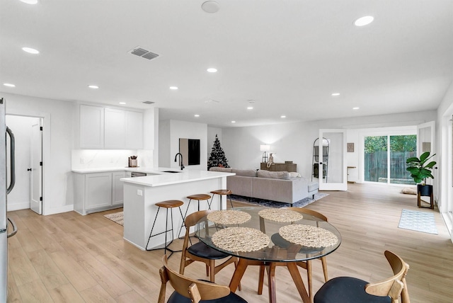 dining space featuring light hardwood / wood-style floors and sink