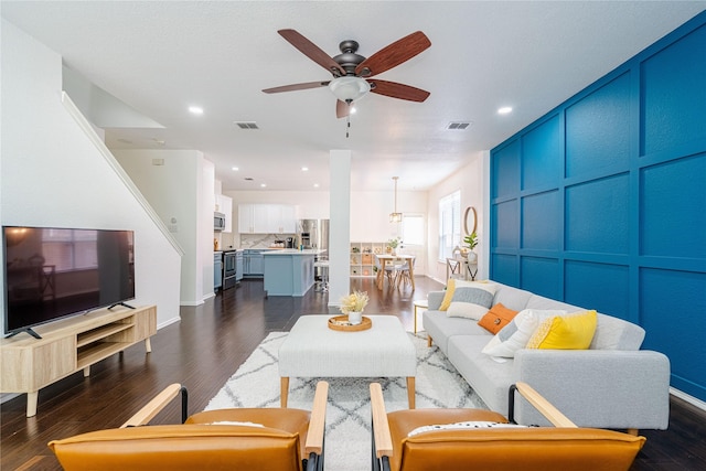 living room featuring dark hardwood / wood-style floors and ceiling fan