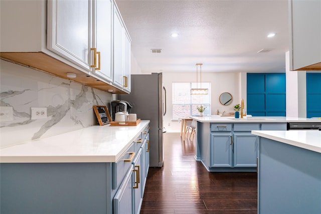 kitchen with backsplash, hanging light fixtures, dark hardwood / wood-style floors, blue cabinetry, and white cabinetry