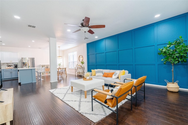 living room with ceiling fan and dark hardwood / wood-style floors