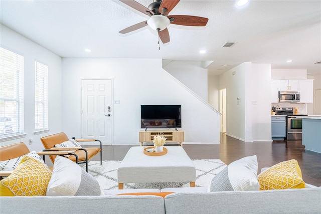 living room featuring ceiling fan and dark hardwood / wood-style flooring