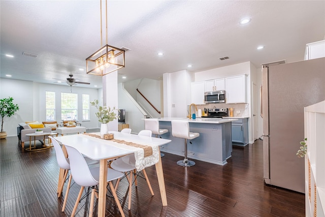 dining area featuring a textured ceiling, ceiling fan, dark hardwood / wood-style floors, and sink