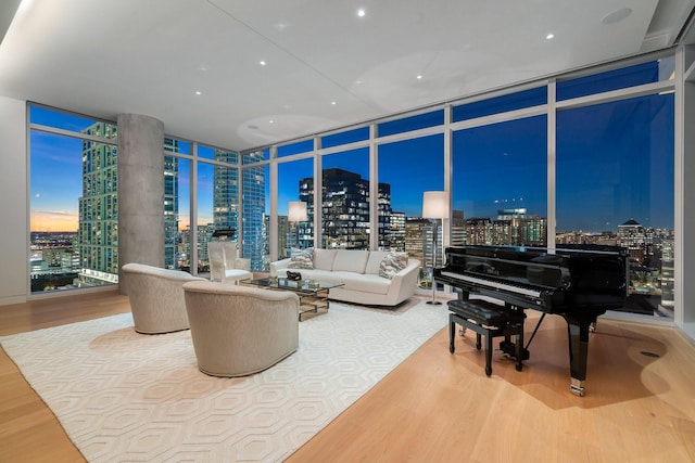 living room with a view of city, a wall of windows, and wood finished floors