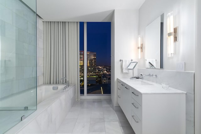 bathroom with vanity and tiled tub