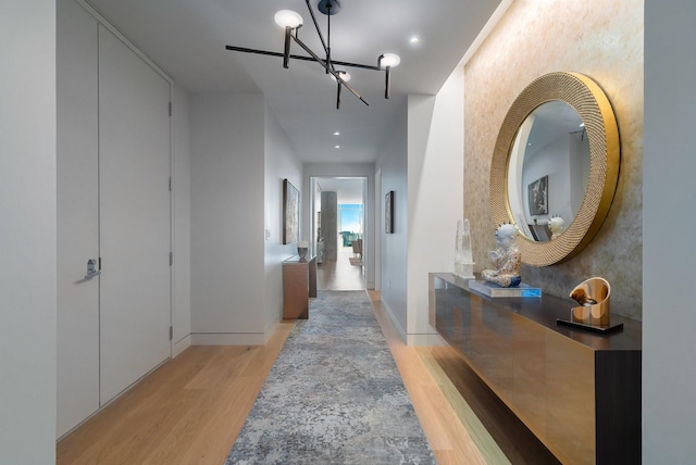 hallway with a chandelier and light hardwood / wood-style flooring