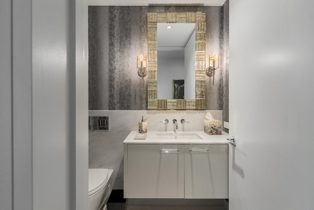 bathroom featuring vanity, toilet, and tile walls