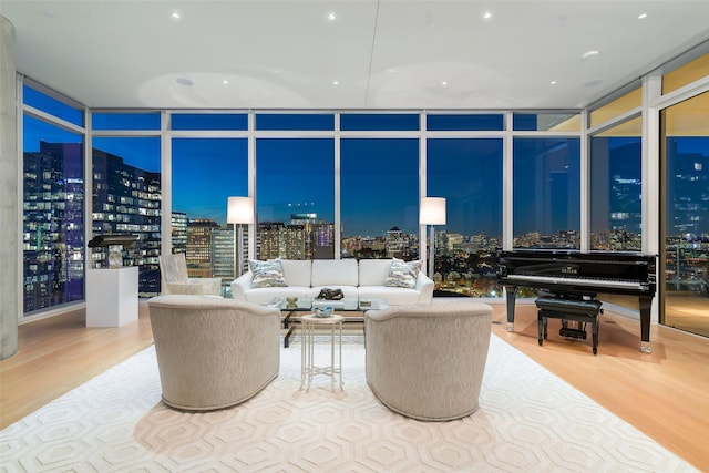 living area featuring a view of city, floor to ceiling windows, and wood finished floors