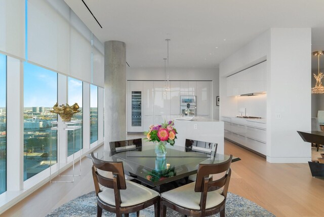 dining space featuring light hardwood / wood-style flooring and beverage cooler