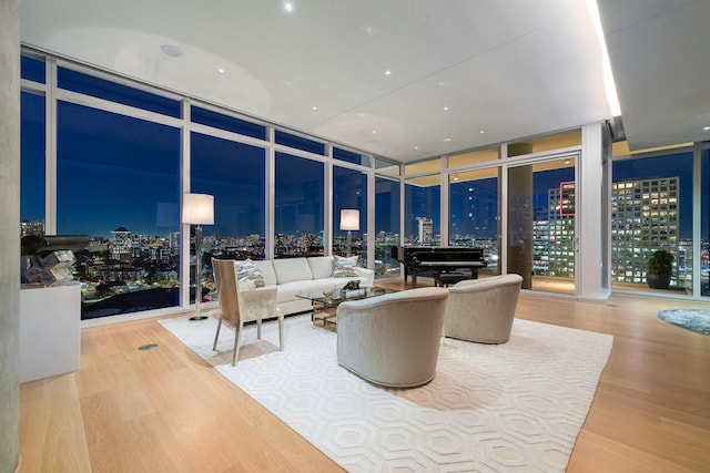 living room with hardwood / wood-style flooring and a wall of windows