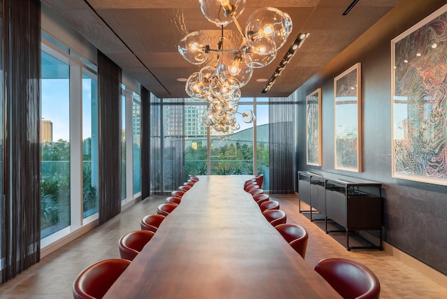 dining area with a chandelier and a wall of windows