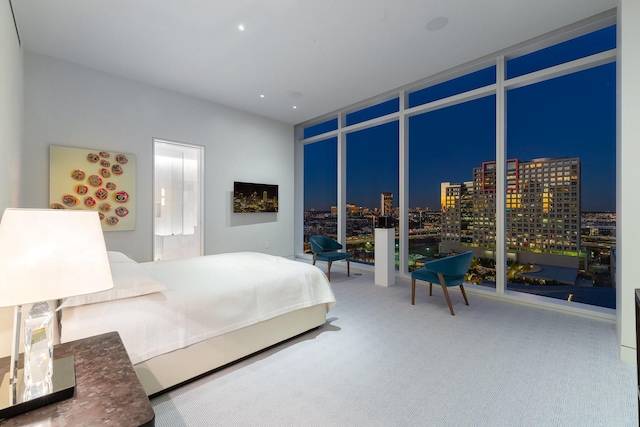 bedroom with carpet floors and a wall of windows