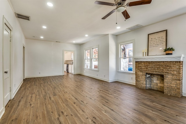 unfurnished living room featuring a fireplace, hardwood / wood-style floors, and ceiling fan