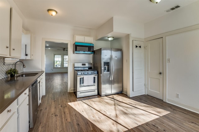 kitchen featuring appliances with stainless steel finishes, light wood-type flooring, ceiling fan, sink, and white cabinetry