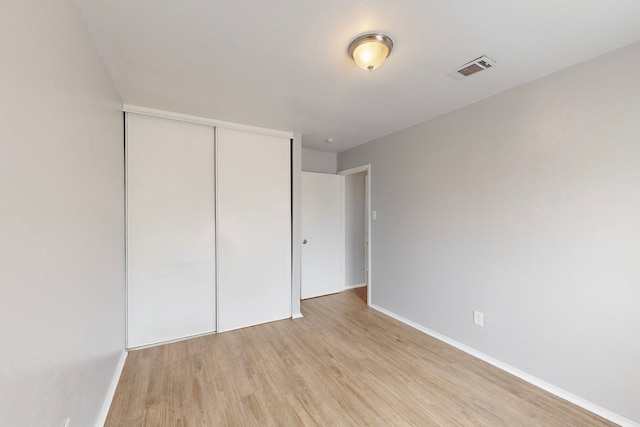 unfurnished bedroom featuring light hardwood / wood-style flooring and a closet