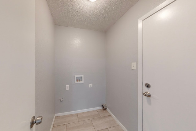 laundry area with hookup for a washing machine, light tile patterned floors, and a textured ceiling