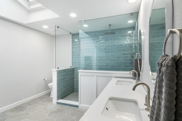 bathroom featuring tile patterned floors, toilet, vanity, and tiled shower